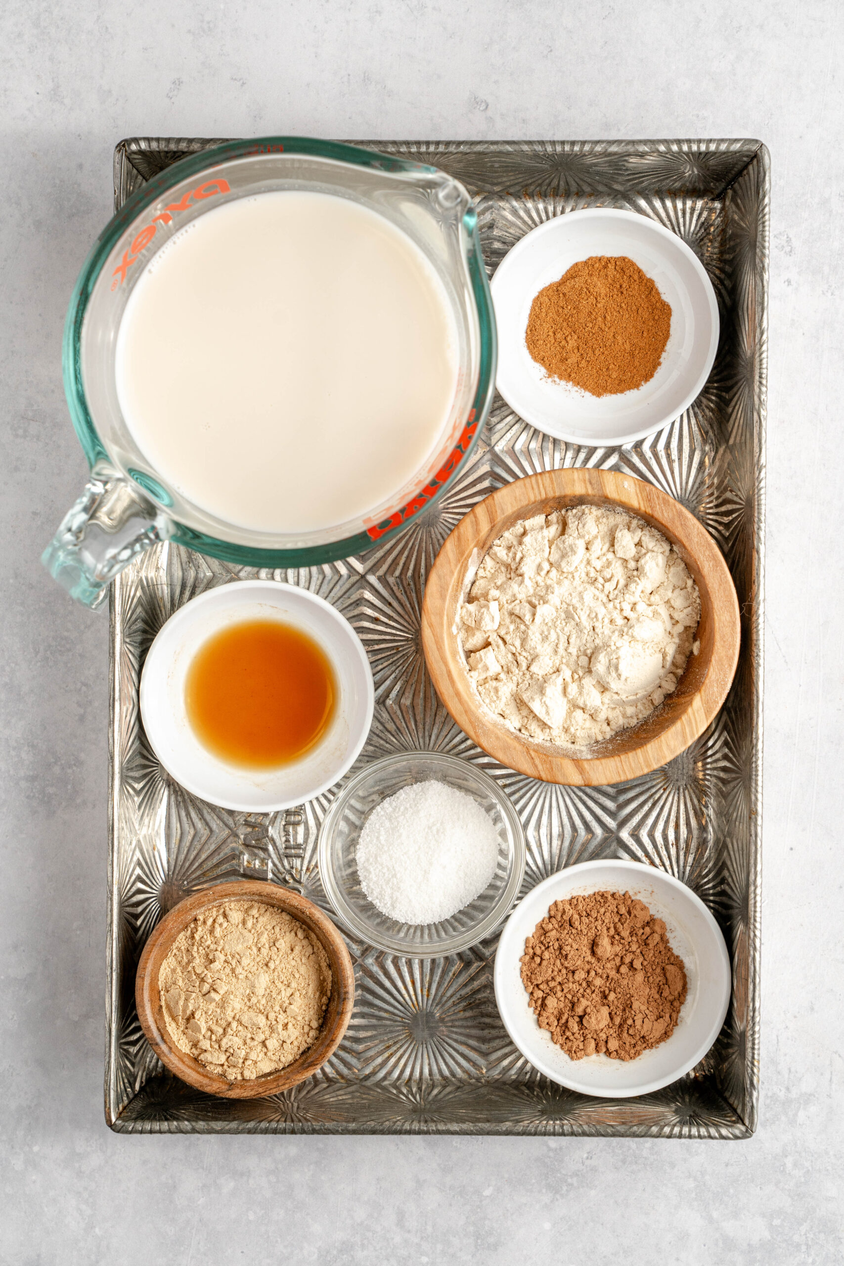 ingredients to make maca latte including: almond milk, maca, cacao powder, protein powder, monk fruit sweetener, and vanilla extract 