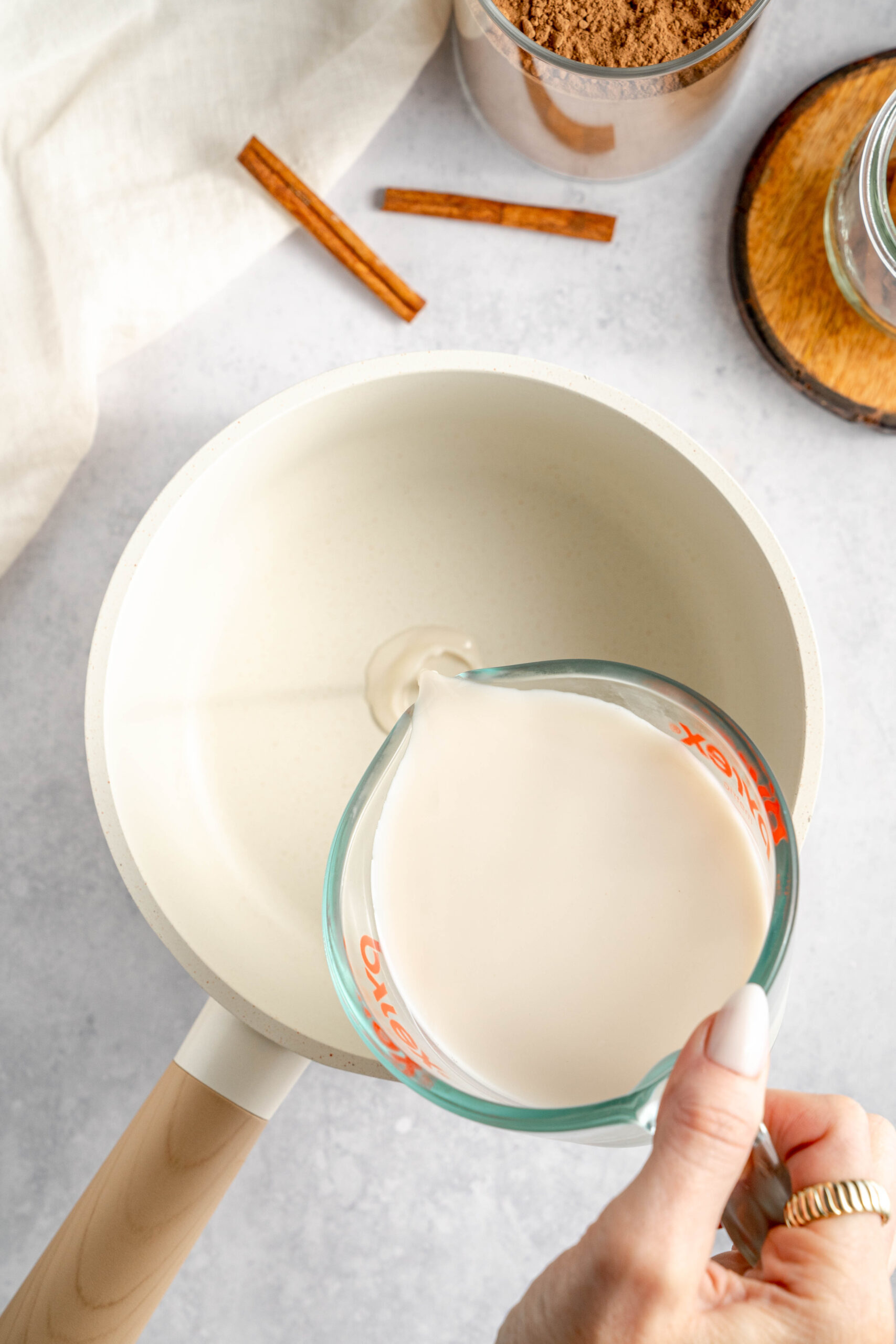 almond milk being poured into saucepan to warm for maca latte
