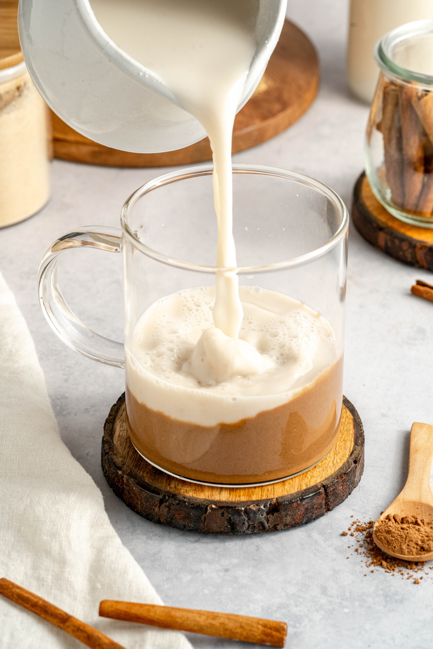 almond milk being poured into maca mixture to make delicious latte